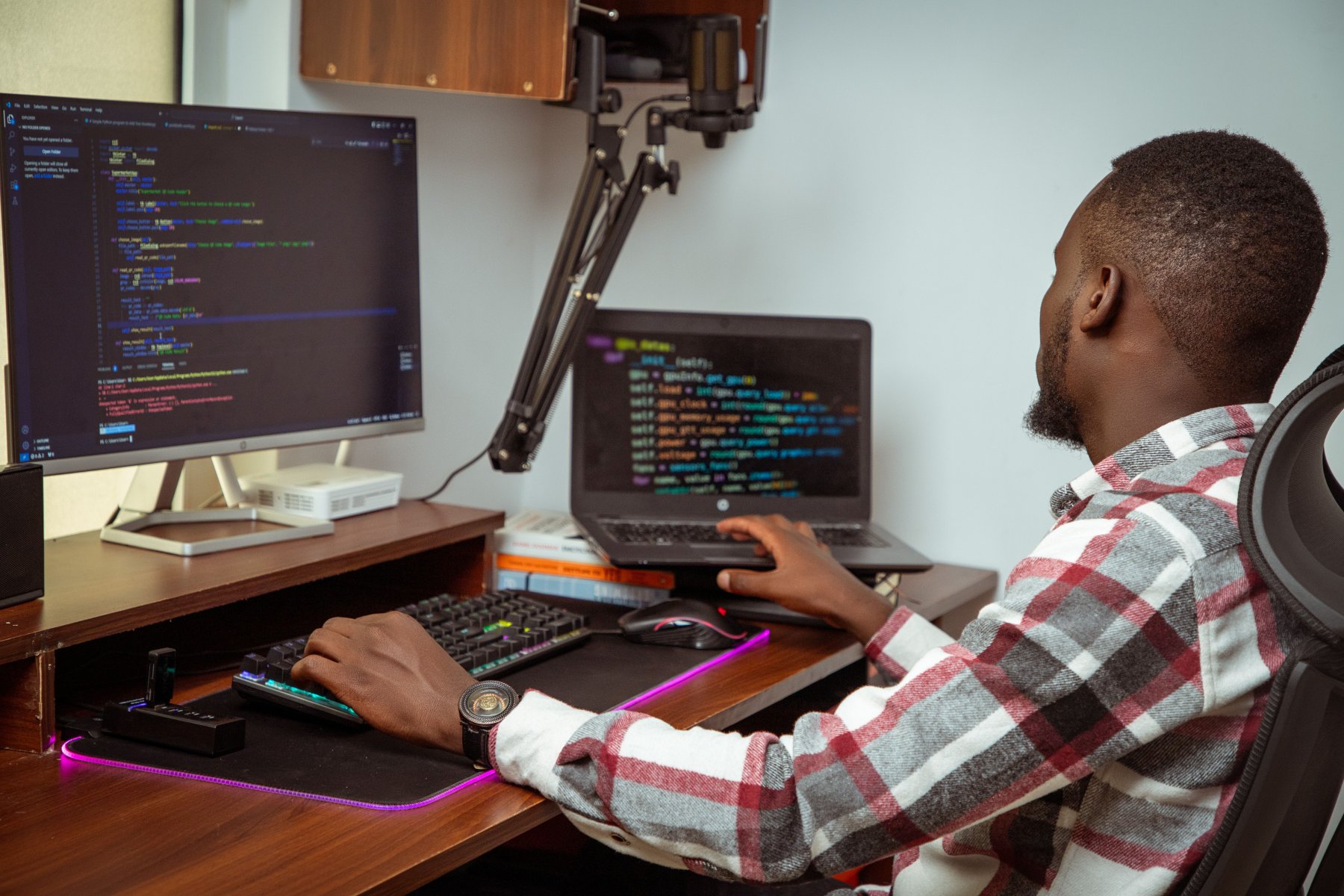 Developer writing code across two monitors