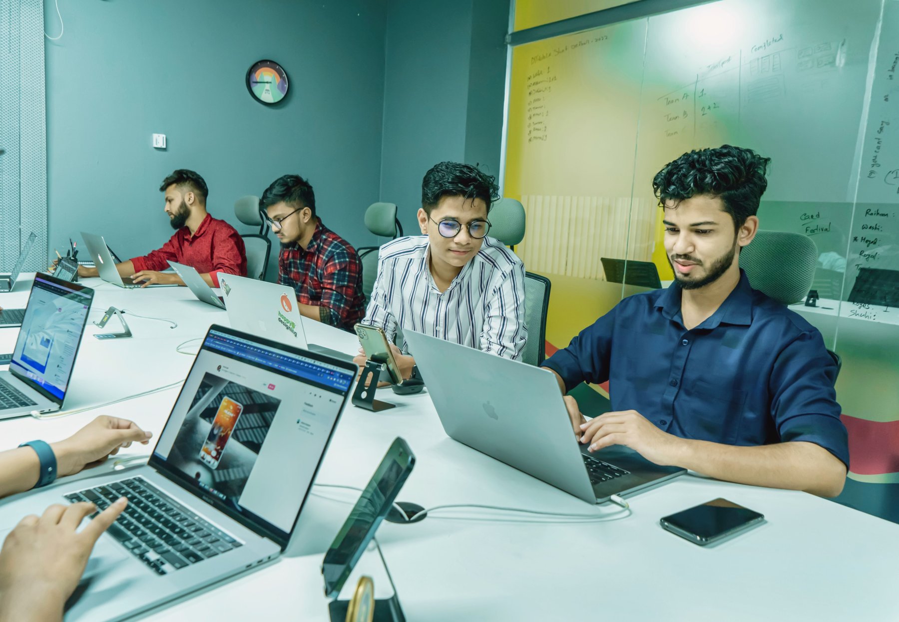 Technology team collaborating around computers